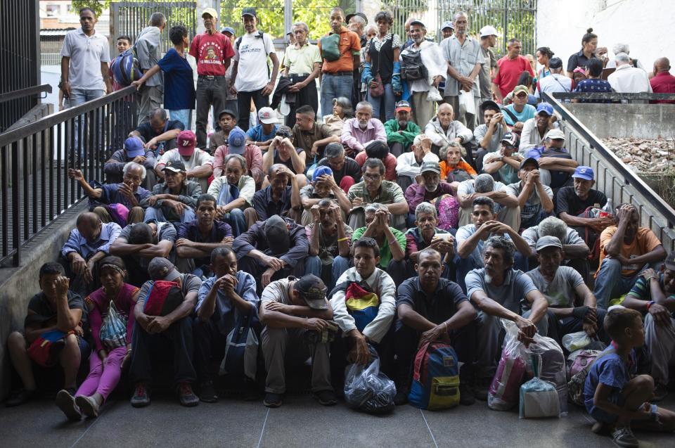 En esta foto del 27 de febrero de 2020, la gente espera afuera de un centro religioso para recibir una comida gratis en el barrio El Cementerio en Caracas, Venezuela. (AP Foto/Ariana Cubillos)