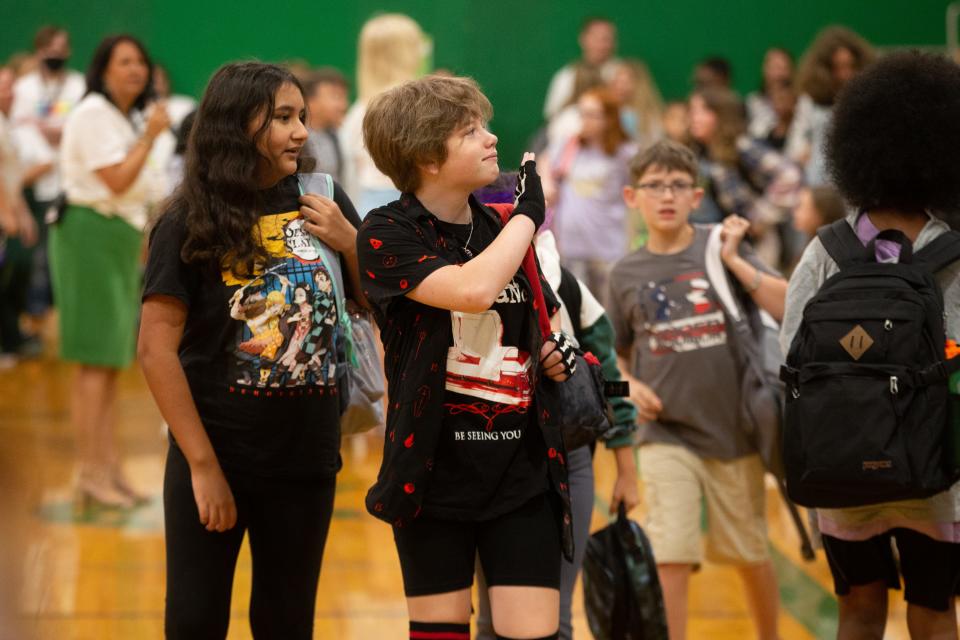 Sixth-grade students, from left, Rosa Garcia, Addy Berthelsen and Parker Wichert leave the gymnasium and familiar faces to meet their home room teachers.