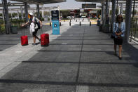 A passenger with his travel cases, walks at Cyprus' main airport at Larnaca on Tuesday, June 9, 2020. Cyprus re-opened its airports on Tuesday to a limited number of countries after nearly three months of commercial air traffic as a result of a strict lockdown aimed at staving off the spread of COVID-19. (AP Photo/Petros Karadjias)