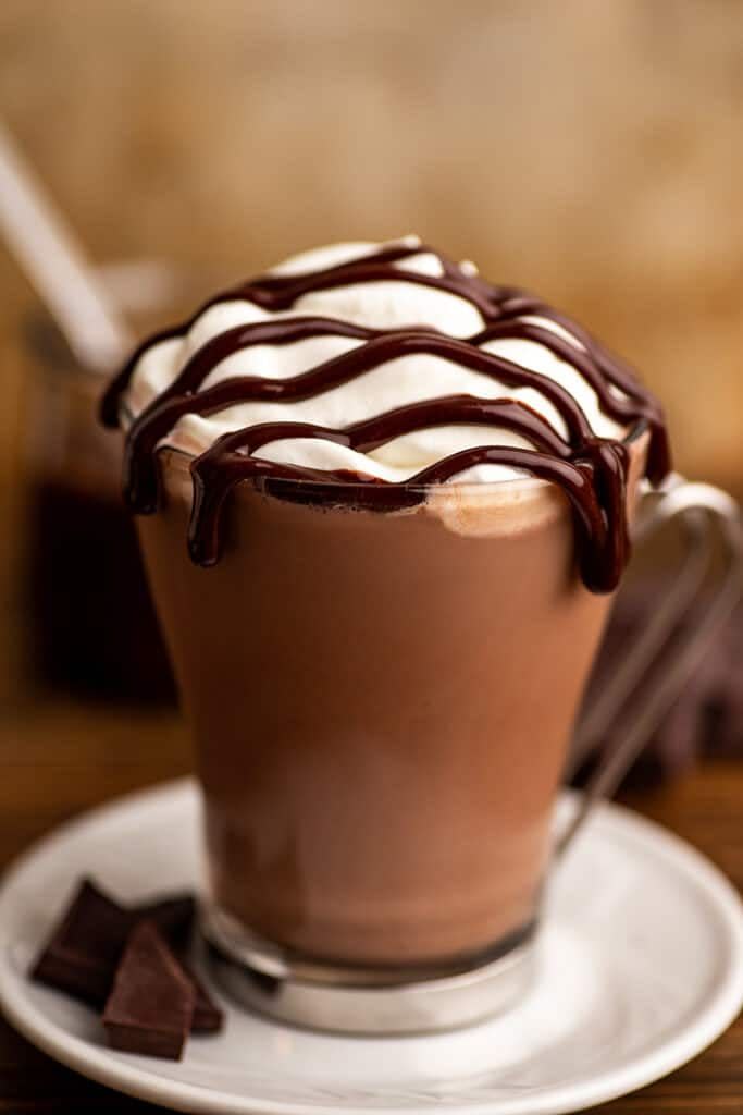 baileys hot chocolate with chocolate drizzle on white plate