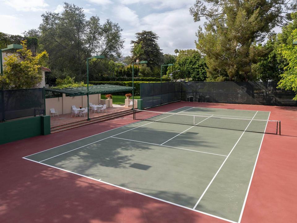 a tennis court surrounded by trees