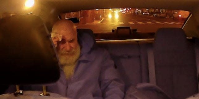 Jerry Daniel Braun holds his head in the back of an Uber.