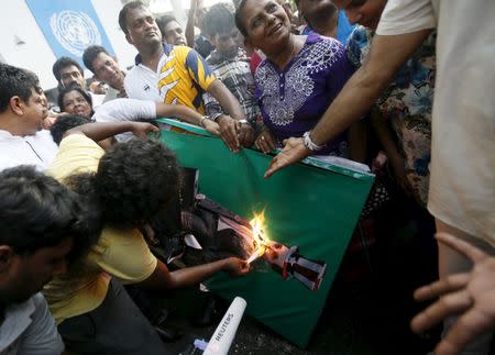 Demonstrators set fire on an image of United Nations (U.N.) High Commissioner for Human Rights Zeid Ra'ad Al Hussein during a protest against his visit, in front of the U.N. head office in Colombo February 6, 2016. REUTERS/Dinuka Liyanawatte