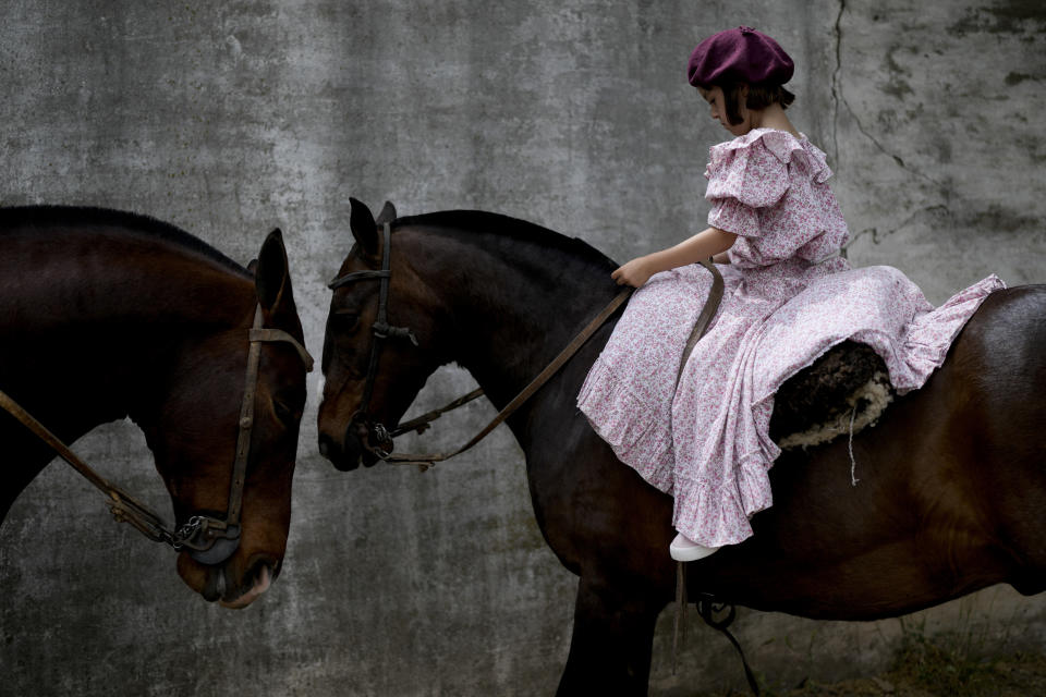 Una niña monta a caballo durante el Día de la Tradición, cuyo objetivo es preservar las tradiciones gauchas, en San Antonio de Areco, Argentina, el 13 de noviembre de 2022. (AP Foto/Natacha Pisarenko)