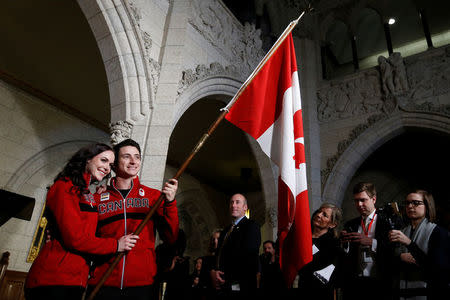 Ice dancers Tessa Virtue and Scott Moir pose with a Canadian flag after being named Canada's flag-bearers for the opening ceremony of the 2018 Pyeongchang Winter Olympic Games during an event on Parliament Hill in Ottawa, Ontario, Canada, January 16, 2018. REUTERS/Chris Wattie