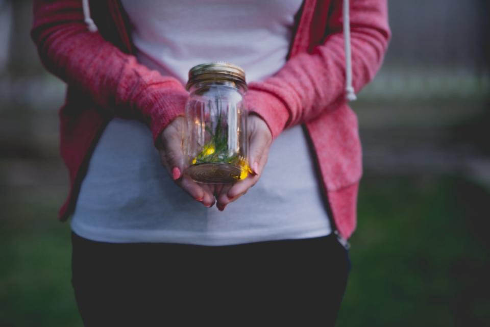 Woman holding a jar of fireflies
