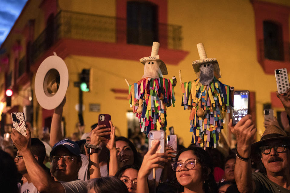 Asistentes toma fotos de un desfile durante el festival de la Guelaguetza en Oaxaca, México, el sábado 15 de julio de 2023. En el el evento promovido por el gobierno, 16 etnias indígenas y la comunidad afromexicana reivindican sus tradiciones a través de bailes, desfiles y venta de artesanías. (AP Foto/María Alférez)