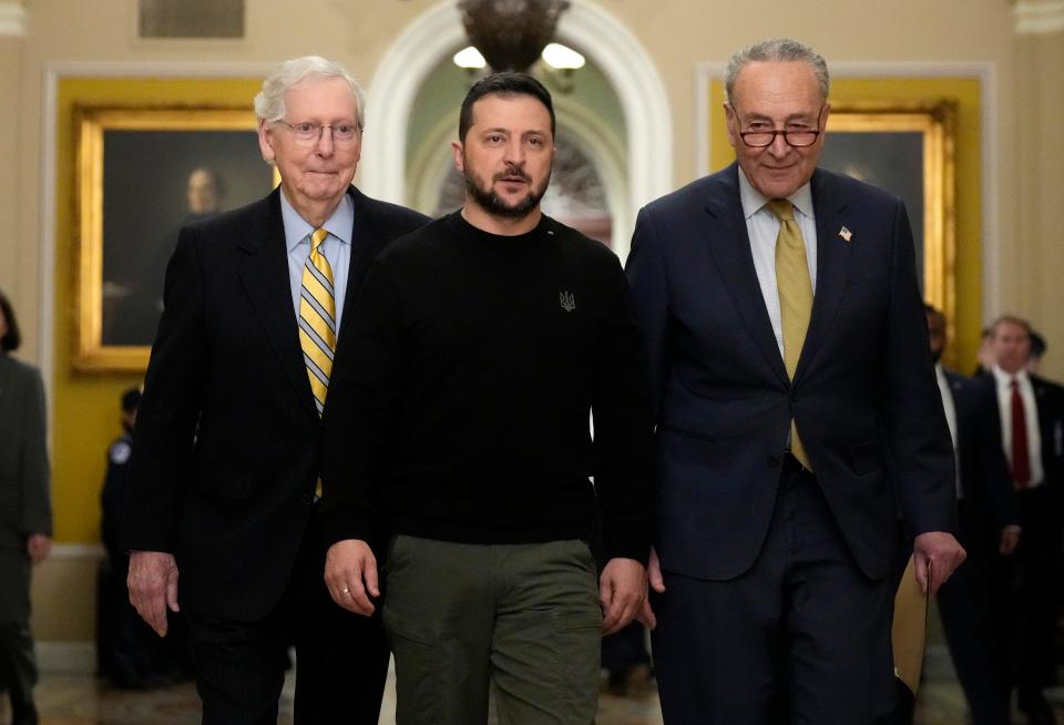 Senate Minority Leader Mitch McConnell walks with Ukrainian President Volodymyr Zelensky and Majority Leader Charles Schumer on Dec. 12, 2023, as the Ukrainian leader requested continuing military aid to expel Russian invaders. The meetings come days after the Senate failed to advance President Biden's national security package that included aid to Ukraine.