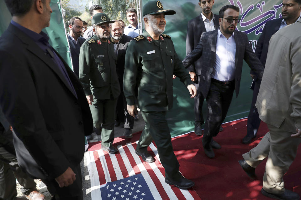 Chief of Iran's Revolutionary Guard Gen. Hossein Salami, center, arrives at a ceremony to unveil new anti-U.S. murals painted on the walls of former U.S. embassy in Tehran, as he steps on the U.S. flag, in Tehran, Iran, Saturday, Nov. 2, 2019. Anti-U.S. works of graphics is the main theme of the wall murals painted by a team of artists ahead of the 40th anniversary of the takeover of the U.S. diplomatic post by revolutionary students. (AP Photo/Vahid Salemi)