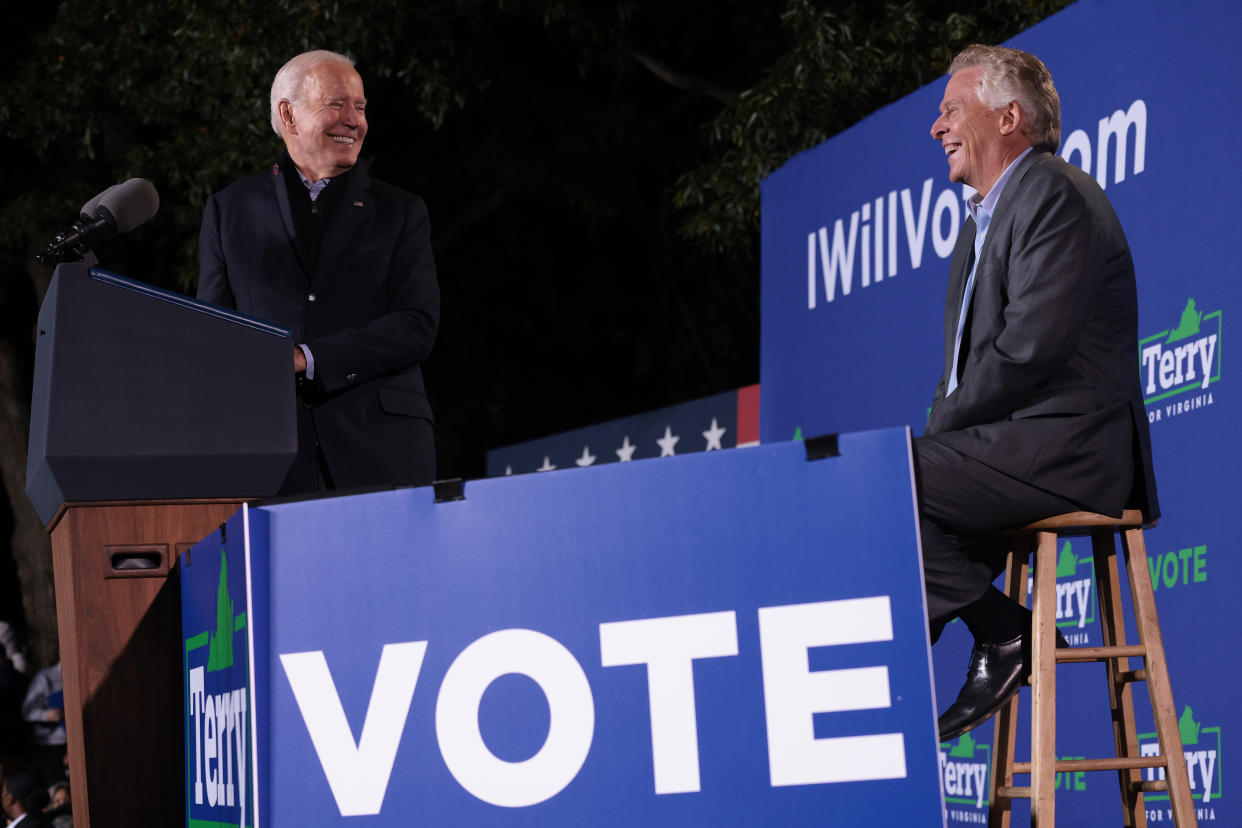 President Biden stands at a podium while campaigning with seated Democratic gubernatorial candidate Terry McAuliffe at Virginia Highlands Park on Tuesday in Arlington, Virginia.