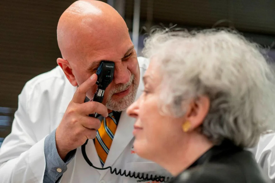 Dr. James Galvin, the director of UM’s Comprehensive Center for Brain Health, examines a patient.