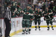 Minnesota Wild right wing Ryan Hartman, center, is congratulated for his goal against the Arizona Coyotes during the second period of an NHL hockey game Tuesday, March 12, 2024, in St. Paul, Minn. (AP Photo/Matt Krohn)