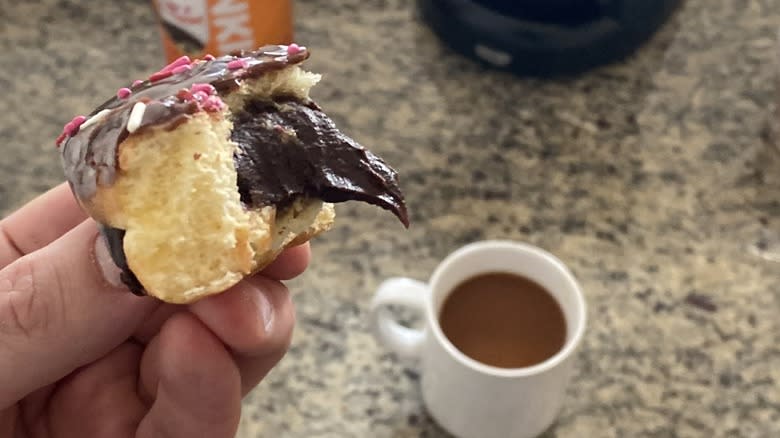 Hand holding oozing brownie batter donut