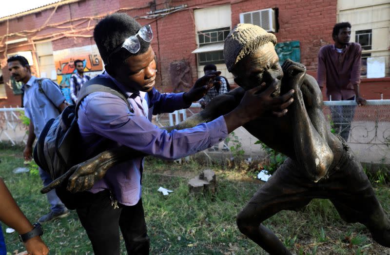 A hearing-impaired student touches a statue at the College of Fine and Applied Arts in Khartoum