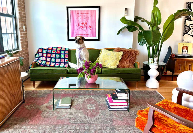 an apartment living room featuring a glass coffee table with books stacked underneath