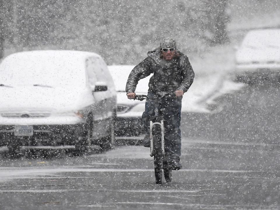 Snow falls as a bicyclist makes his way along Caroline Street in Staunton on Wednesday, Dec. 5, 2018.