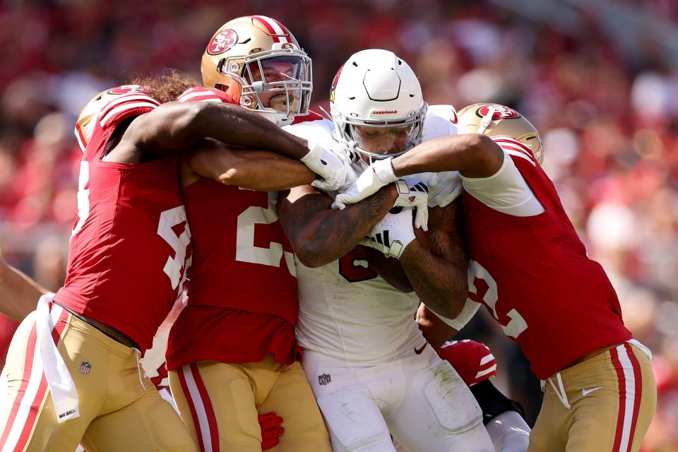 James Conner (6) of the Arizona Cardinals is tackled by multiple members of the San Francisco 49ers defense during the second quarter at Levi's Stadium on Oct. 1, 2023, in Santa Clara, California.