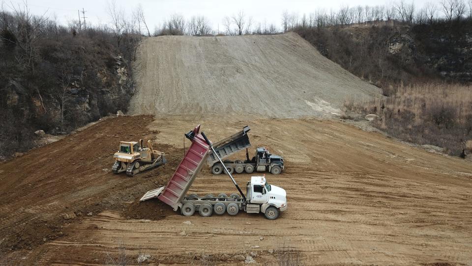 Trucks deliver dirt to the new sledding hill under construction at Quarry Trails Metro Park.