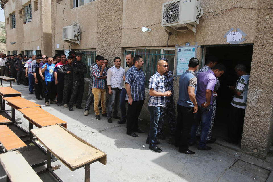 Iraqi security forces queue to vote outside a polling center in Baghdad, Iraq, Monday, April 28, 2014. Iraqi officials say suicide bombers have targeted polling centers as soldiers and security forces cast ballots ahead of parliamentary elections. (AP Photo/Karim Kadim)