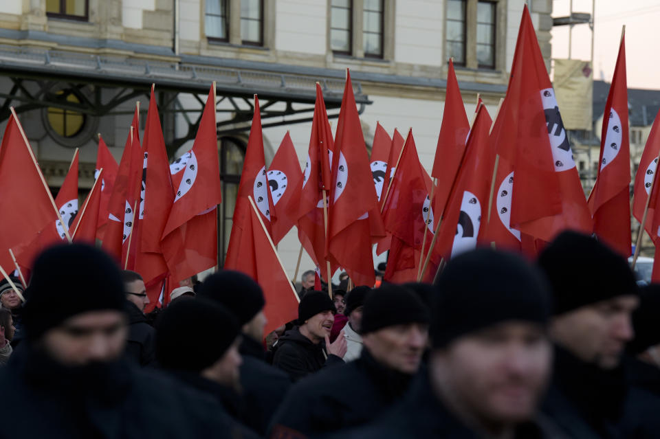 Police officers walk non front of a demonstration against the visit of German Chancellor Angela Merkel at the East German city Chemnitz on Friday, Nov. 16, 2018. (AP Photo/Jens Meyer)