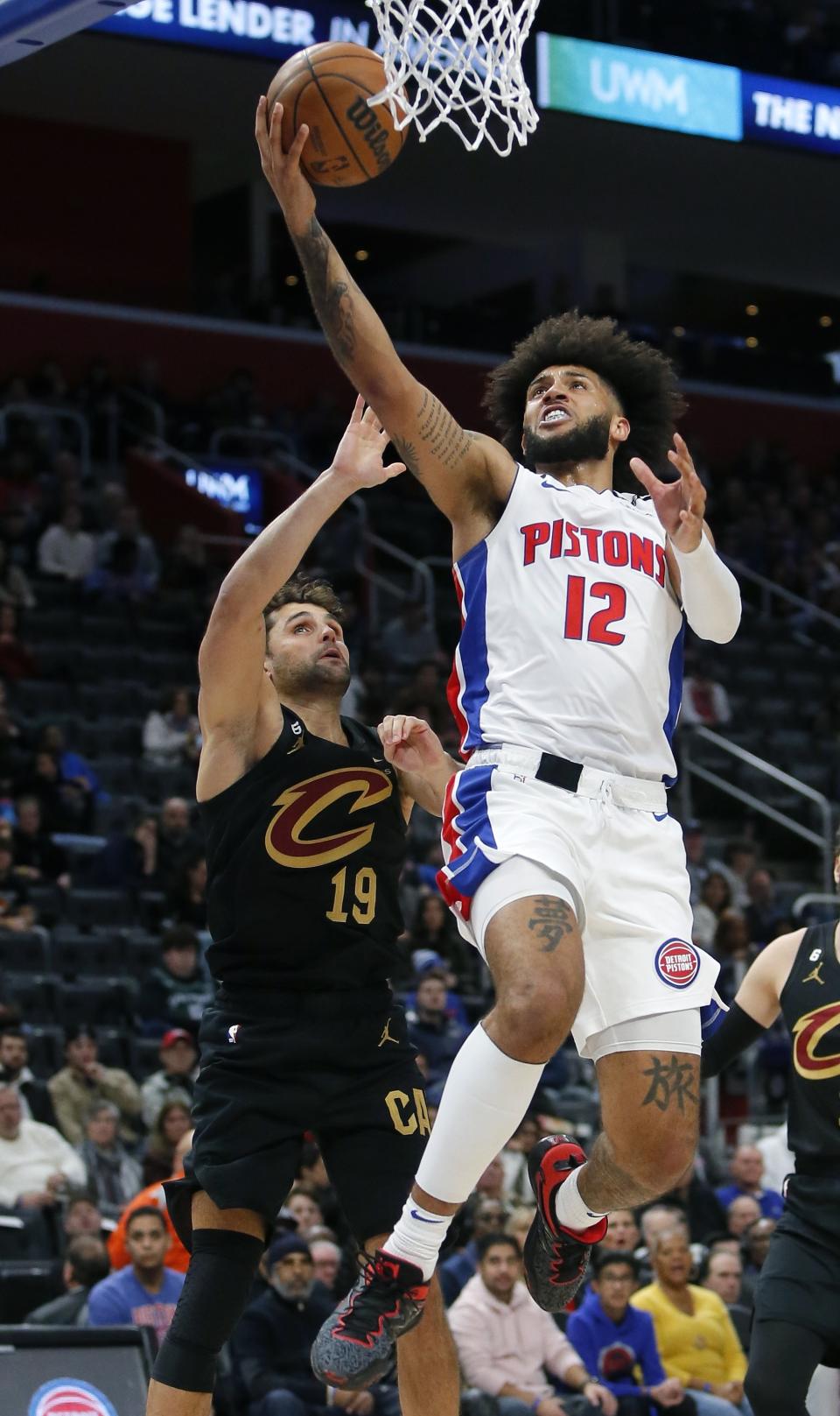 Detroit Pistons forward Isaiah Livers (12) goes to the basket against Cleveland Cavaliers guard Raul Neto (19) during the first half of an NBA basketball game Sunday, Nov. 27, 2022, in Detroit. (AP Photo/Duane Burleson)