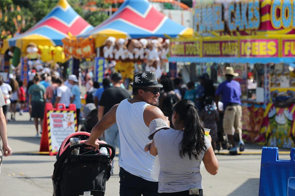 Fair-goers walked down the midway on the last day of the Kentucky State Fair in Louisville, Ky. on Aug. 29 2021.  