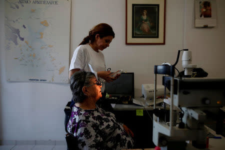 Dionysia Amorgianou, 82, is examined by a volunteer oculist of the Aegean Team on the islet of Thymaina, Greece, May 11, 2017. REUTERS/Alkis Konstantinidis