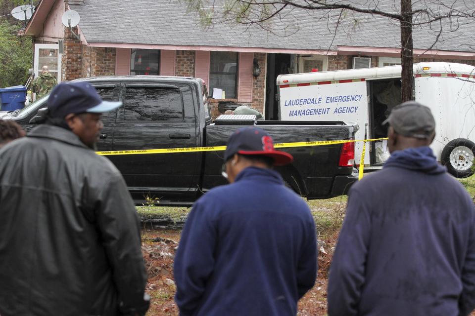 Family members and friends look on as Lauderdale County authorities investigate the shooting deaths of four members of a family in Toomsuba, Miss., Tuesday, Feb. 21, 2017. (Paula Merritt /The Meridian Star via AP)