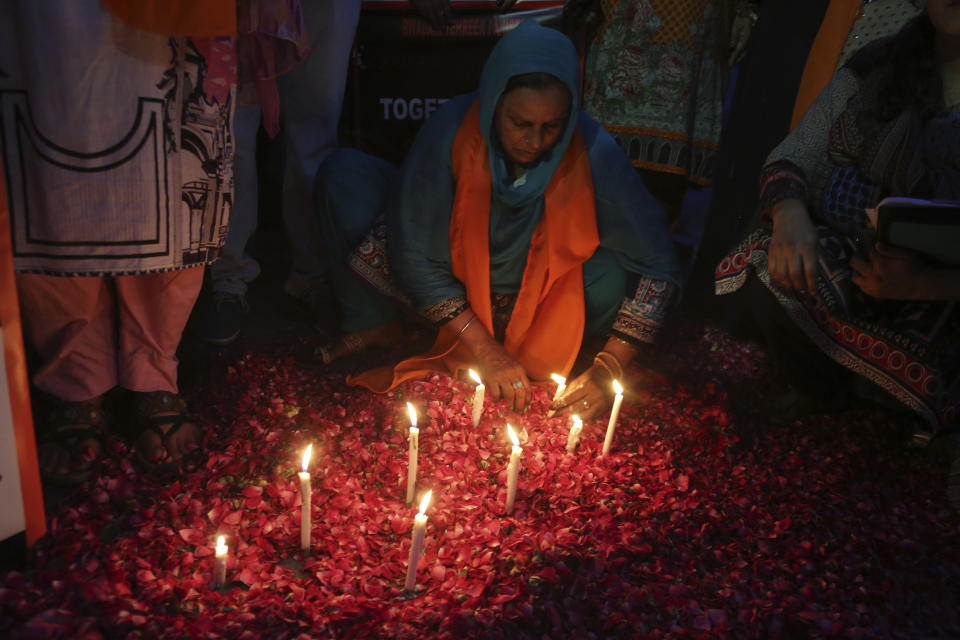 A Pakistani woman lights candles during a vigil for the victims of bomb explosions in churches and hotels in Sri Lanka, in Lahore, Pakistan, Tuesday April 23, 2019. The death toll from the Easter Sunday bombings in Sri Lanka, rose Tuesday to more than 300. (AP Photo/K.M. Chaudary)