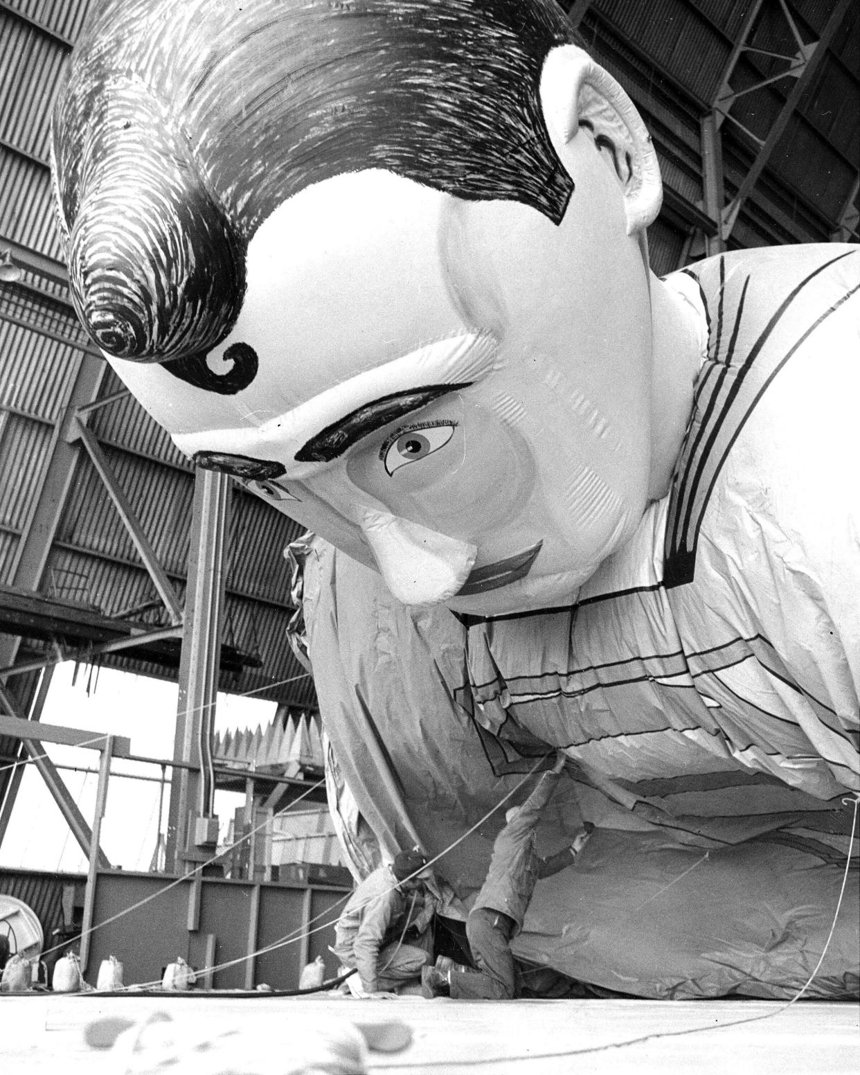 Workers filling Superman with helium for the parade