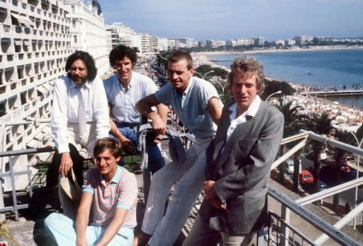 Los actores y el director de la película 'Carros de fuego' (de izq a dcha, Ian Charleson, Nigel Havers -abajo-, Ben Cross, Daniel Gerroll y Hugh Hudson) posan en la terraza de su hotel el 20 de mayo del año 1981, durante el Festival Internacional de Cine de Cannes (Francia). (AFP/Archivo | )