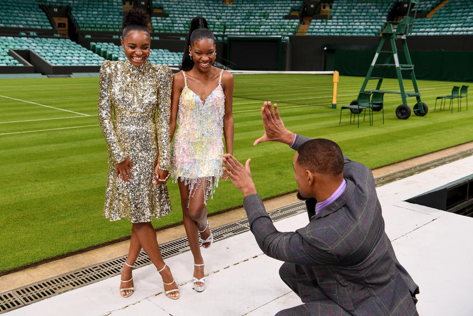 <p>Will Smith takes an imaginary snap of his <em>King Richard</em> costars Saniyya Sidney and Demi Singleton at the All England Lawn Tennis and Croquet Club in London on Nov. 17. </p>