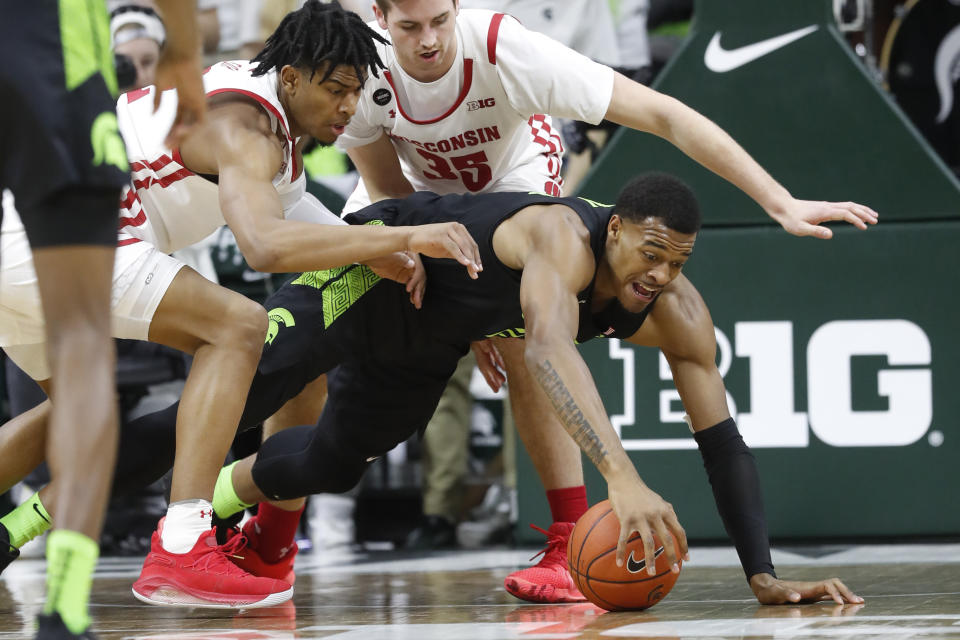 Wisconsin forward Aleem Ford, left, and Michigan State forward Xavier Tillman chase the ball during the first half of an NCAA college basketball game, Friday, Jan. 17, 2020, in East Lansing, Mich. (AP Photo/Carlos Osorio)