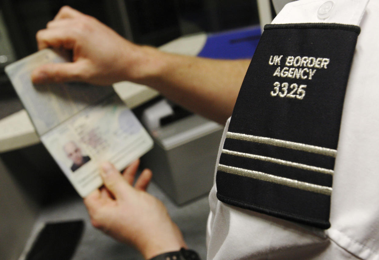 A UK Border Agency worker poses with a passport during a demonstration of the new facial recognition gates at the North Terminal of Gatwick Airport near London, November 23, 2009. The gates can be used by any British or EEA national who holds a biometric passport and are designed to speed travellers through immigration control.   REUTERS/Luke MacGregor   (BRITAIN TRANSPORT TRAVEL)