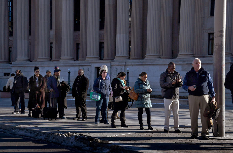 <p>Workers wait for a commuter bus in front of the Archives building on Pennsylvania Ave. in NW Washington. (Photo: Michael S. Williamson/The Washington Post via Getty Images) </p>