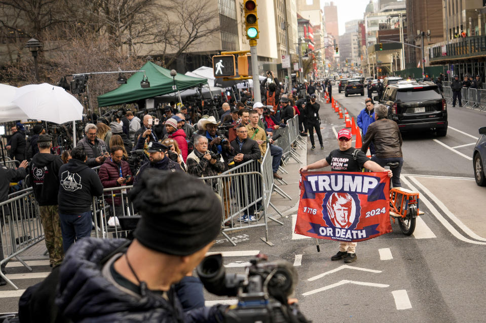 Partidarios del expresidente Donald Trump se aglomeran frente a la prensa y espectadores fuera de la corte criminal de Manhatta, martes 4 de abril de 2023. La leyenda en el cartel dice "Trump o muerte". (AP Foto/John Minchillo)