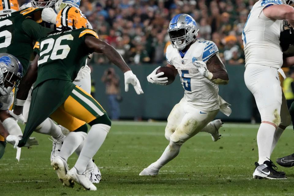 Detroit Lions running back David Montgomery (5) runs from Green Bay Packers safety Darnell Savage (26) during the second half at Lambeau Field in Green Bay, Wisconsin, on Thursday, Sept. 28, 2023.