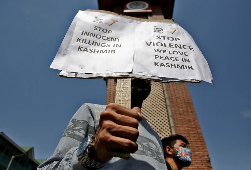 A demonstrator displays a placard during a protest against minorities killings in Kashmir, in Srinagar