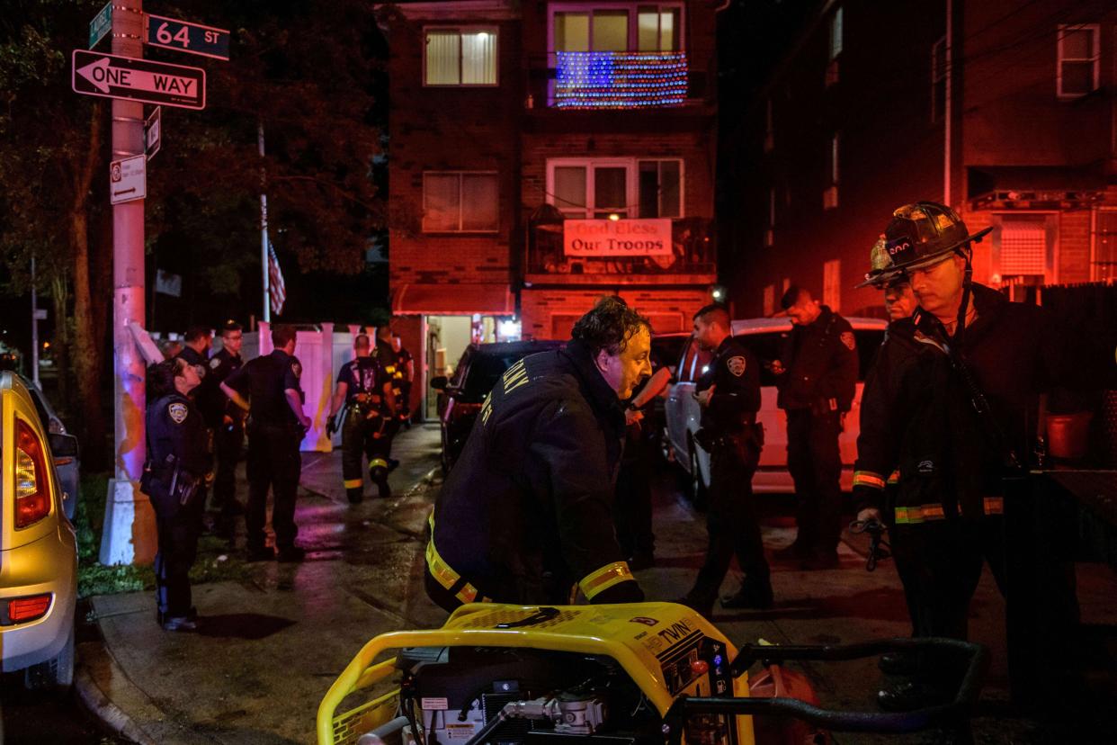Police officers and rescue workers gather outside a house where a person was trapped in a flooded basement in Queens, New York early on Sept. 2, 2021, as flash flooding and record-breaking rainfall brought by the remnants of Storm Ida swept through the area.