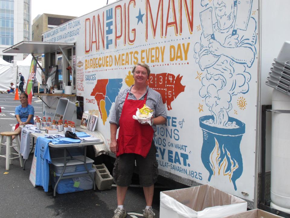 Dan Huntley, also known as "Dan the Pig Man" holds up one of his barbecue sandwiches outside his food truck in Charlotte, N.C. on Tuesday, Sept. 4, 2012. Huntley had his best day ever during the convention, selling $10,000 worth of sandwiches. (AP Photo/Jeffrey Collins)