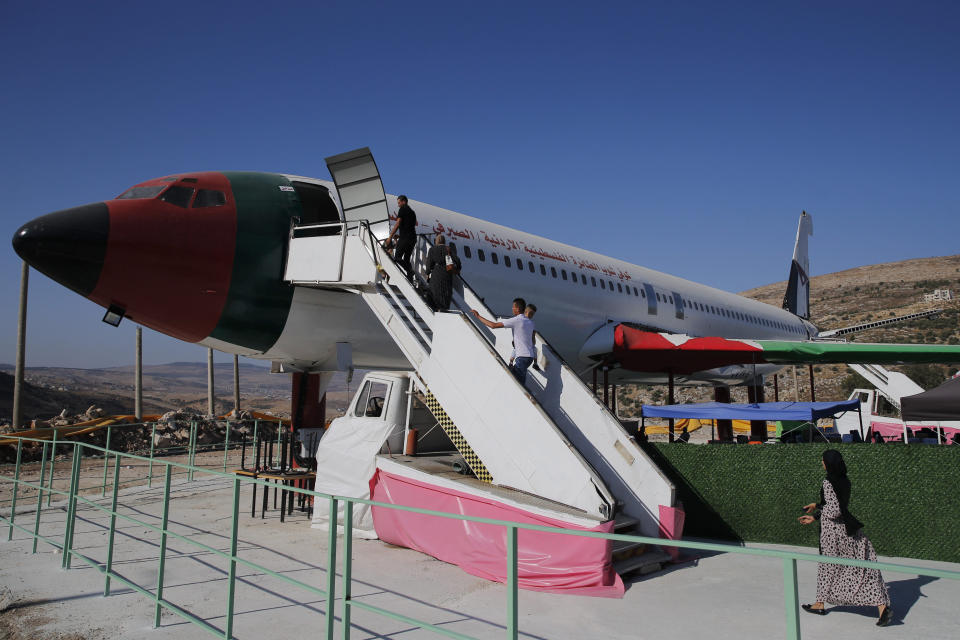 Palestinians visit a Boeing 707 aircraft after it was converted to a restaurant in Wadi Al-Badhan near the West Bank city of Nablus, Wednesday, Aug. 11, 2021. The Palestinian territory has no civilian airport and those who can afford a plane ticket must catch their flights in neighboring Jordan. After a quarter century of effort, twins brothers, Khamis al-Sairafi and Ata, opened the “Palestinian-Jordanian Airline Restaurant and Coffee Shop al-Sairafi” on July 21, 2021, offering people an old airplane for customers to board. (AP Photo/Majdi Mohammed)