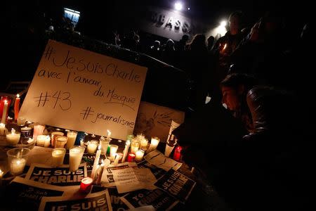 A woman of the French community places a candle for the victims of the shooting by two Islamist gunmen at the Paris offices of the satirical French newspaper Charlie Hebdo, outside the French embassy in Mexico City, January 8, 2015. REUTERS/Bernardo Montoya