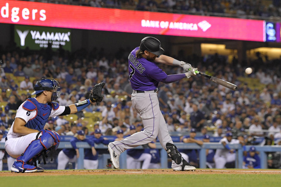Colorado Rockies' Brendan Rodgers, right, hits a solo home run as Los Angeles Dodgers catcher Austin Barnes watches during the first inning of a baseball game Tuesday, Oct. 4, 2022, in Los Angeles. (AP Photo/Mark J. Terrill)