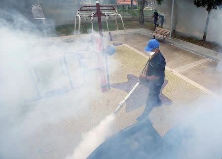 A worker fogs a community playground at a new Zika cluster area in Singapore September 1, 2016. REUTERS/Edgar Su