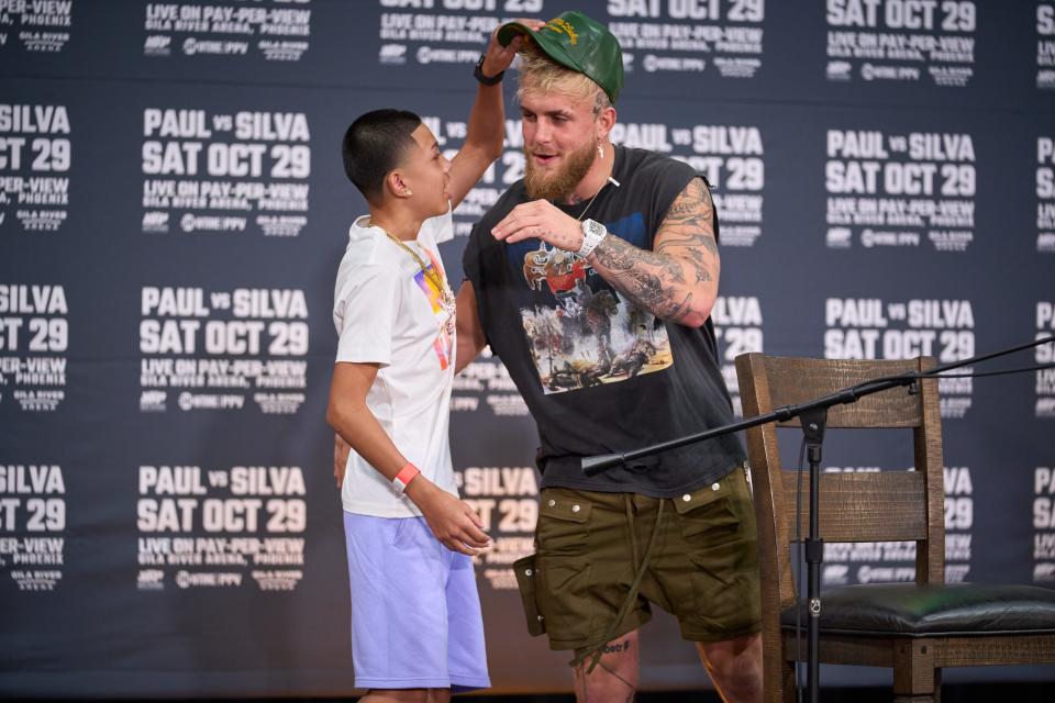 Sep 13, 2022; Glendale, Arizona, USA; David Garcia, 13, steals Jake Paul's hat as Paul goes to hug him during a press conference at Gila River Arena.