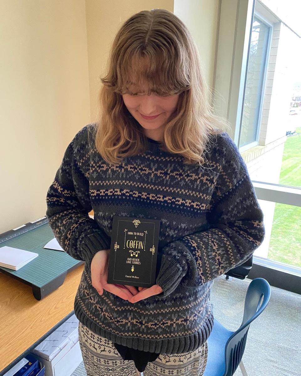 Zoe Gianfrancesco, a senior at the Lincoln Park Performing Arts Charter School, holds a finished copy of the new book by best-selling author Daniel Wallace. Lincoln Park's student press is publishing the book.