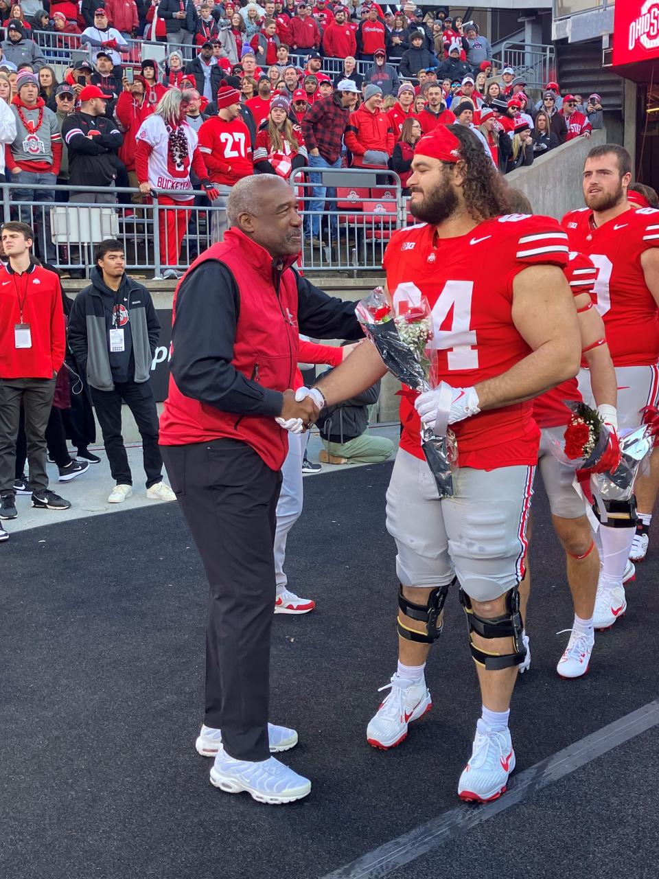 Former Lancaster standout Quinton Burke shakes hands with Ohio State athletic director Gene Smith before Burke was introduced during the Buckeyes' Senior Day on Saturday, Nov. 18 at Ohio Stadium.