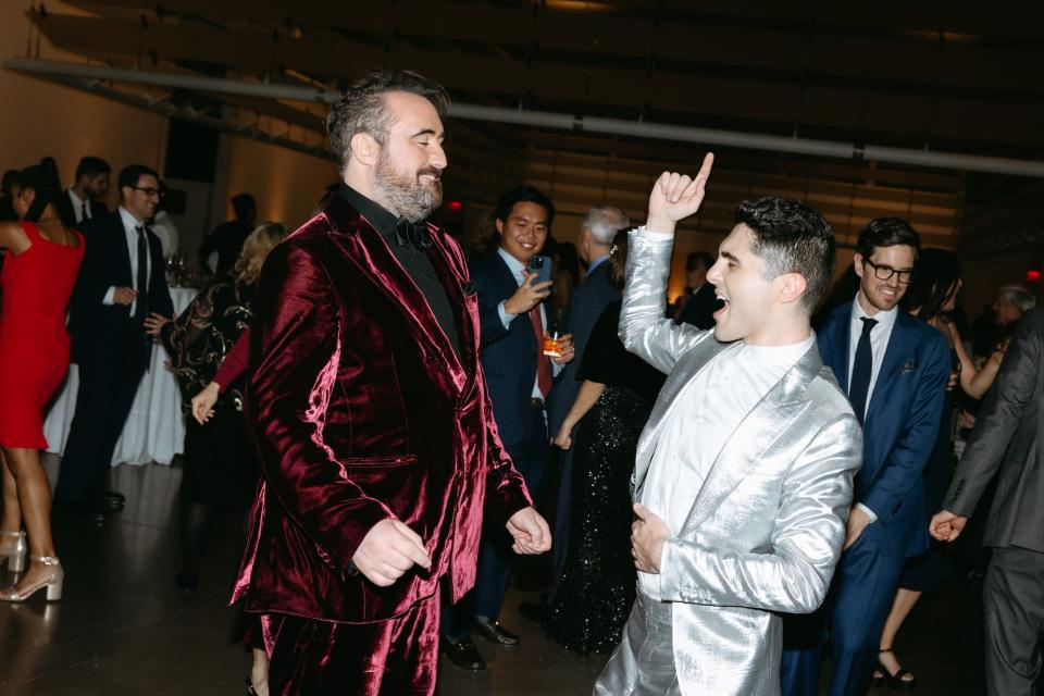 Two grooms dance at their wedding reception.