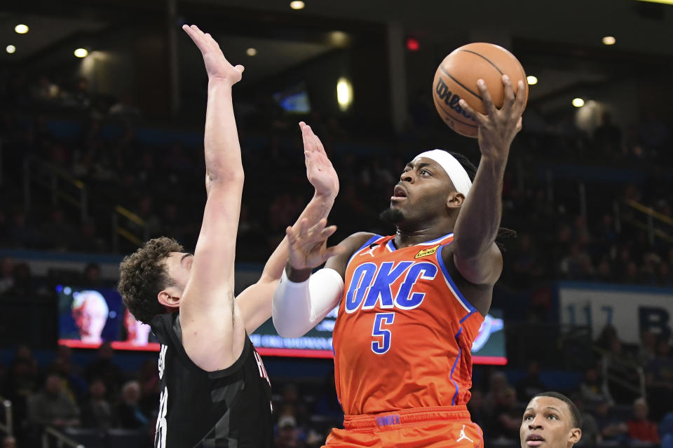 Oklahoma City Thunder forward Luguentz Dort, left, goes up for a shot past Houston Rockets center Alperen Sengun, left, in the second half of an NBA basketball game, Wednesday, Feb. 15, 2023, in Oklahoma City. (AP Photo/Kyle Phillips)