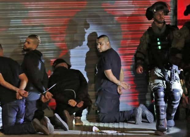 Israeli forces detain a group of Arab Israelis in the mixed Jewish-Arab city of Lod after they clashed with Israeli far-right extremists. 